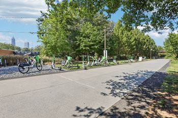 A row of bicycles are parked on the side of a road.